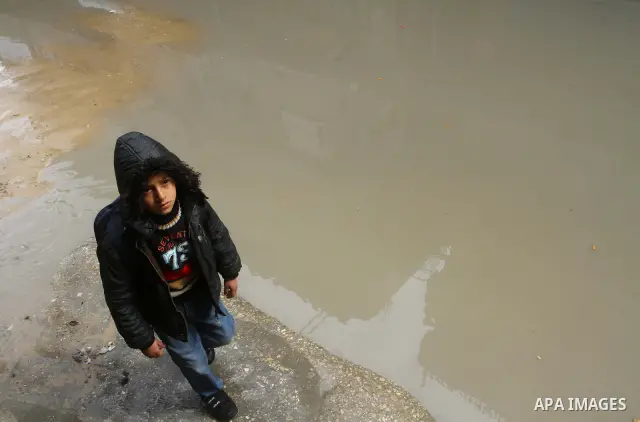 Palestinians walk in a street during the heavy rain of the winter, in the Gaza City, Feb. 19, 2012. Photo by Ashraf Amra