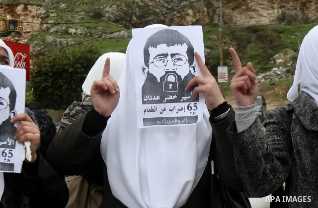 Palestinian women hold posters with the image of Khader Adnan, a senior member of Islamic Jihad jailed in Israel who has been on hunger strike for 64 days, during a protest calling for the release of Adnan and other Pale...