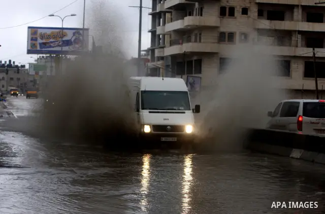 Palestinians walk in a street during the heavy rain of the winter, in west bank City of Ramallah, Feb. 19, 2012. Photo by Issam Rimawi