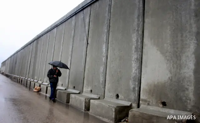 Palestinians walk in a street during the heavy rain of the winter, in west bank City of Ramallah, Feb. 19, 2012. Photo by Issam Rimawi