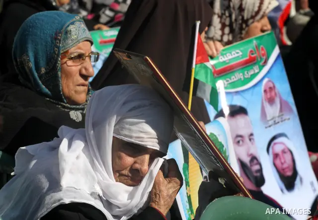Palestinians women hold posters depicting Palestinian prisoner Khader Adnan, a member of the Islamic Jihad militant group, during a protest in front of the Red Cross in Gaza City, calling for the release of Palestinian p...