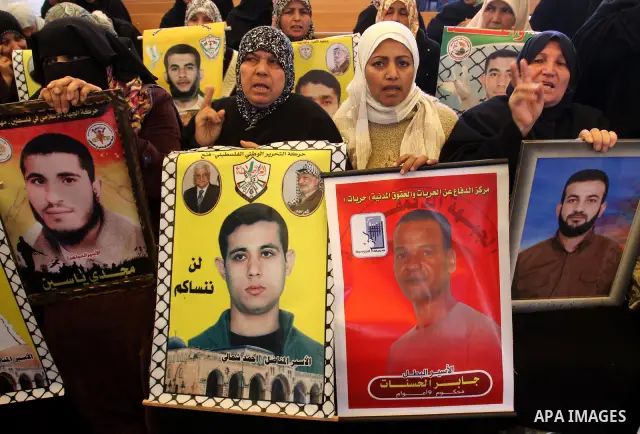 Palestinians women hold posters depicting Palestinian prisoner Khader Adnan, a member of the Islamic Jihad militant group, during a protest in front of the Red Cross in Gaza City, calling for the release of Palestinian p...