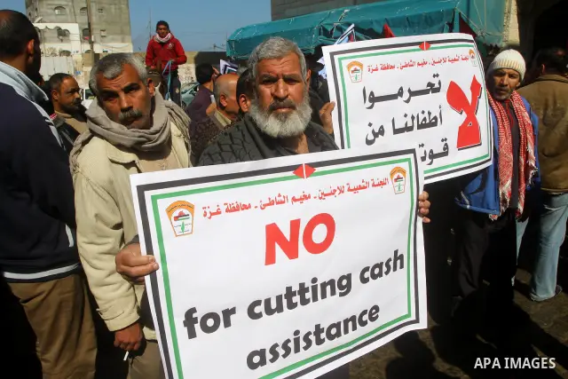 Palestinians take part in a protest in front of the UNRWA (United Nations Relief and Works Agency ) in the Shati refugee camp, in Gaza City, on Feb. 02, 2012 , as UNRWA announced that it will reduce its services for Pale...