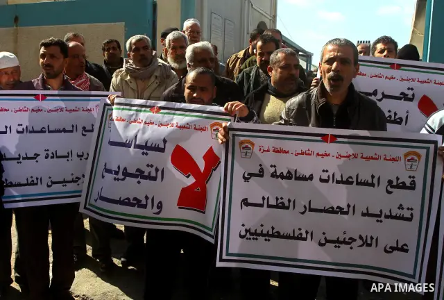 Palestinians take part in a protest in front of the UNRWA (United Nations Relief and Works Agency ) in the Shati refugee camp, in Gaza City, on Feb. 02, 2012 , as UNRWA announced that it will reduce its services for Pale...