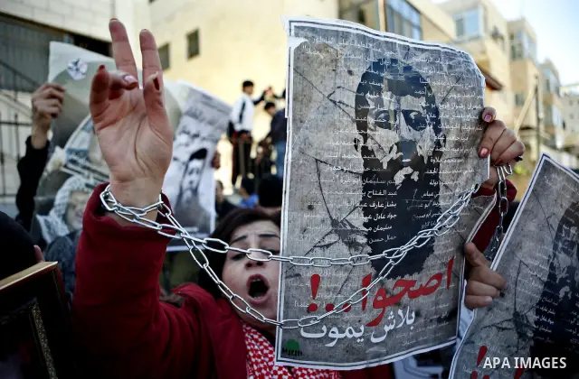 Palestinians hold posters with the image of Khader Adnan, a senior member of Islamic Jihad jailed in Israel who has been on hunger strike for 65 days, during a protest calling for the release of Adnan and other Palestini...