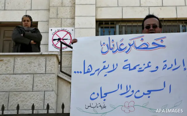 Palestinians hold posters with the image of Khader Adnan, a senior member of Islamic Jihad jailed in Israel who has been on hunger strike for 65 days, during a protest calling for the release of Adnan and other Palestini...