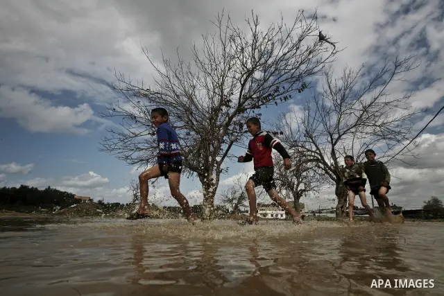 Palestinian children play in a flooded street after heavy rainfall in Jabaliya Refugee camp, the Gaza Strip, 19 February 2012. The Levant region has reportedly seen a high level of rainfall and snow over the past month....
