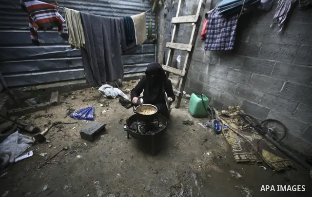 A Palestinian woman cooks inside her family home in the Jabaliya Refugee camp, Gaza Strip, 19 February 2012. The United Nations Relief and Works Agency (UNRWA) states that the Israeli blockade on Gaza has made life more...
