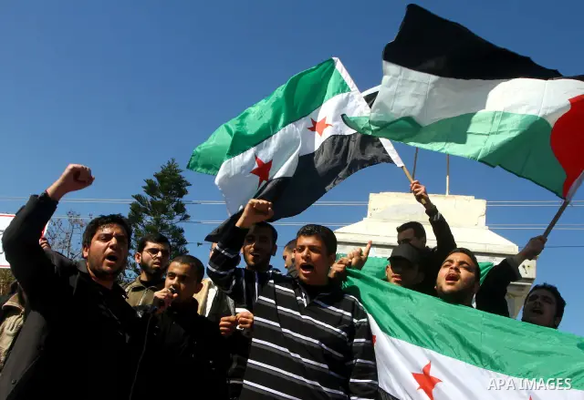 Palestinians holding Syrian flag and banners shout slogans during a protest in solidarity with Syrian people and against the Syrian government headed by president Bashar al-Asad, in Gaza city on Feb. 21,2012. Photo by As...