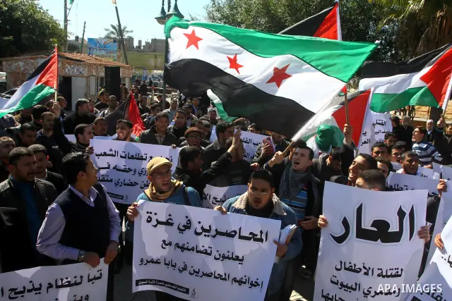Palestinians holding Syrian flag and banners shout slogans during a protest in solidarity with Syrian people and against the Syrian government headed by president Bashar al-Asad, in Gaza city on Feb. 21,2012. Photo by As...
