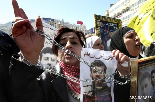 Palestinians hold posters with the images of Khader Adnan Islamic Jihad leader , who is on hunger strike to protest against his detention by Israel, during a rally supporting , in the city of Nablus West Bank , Feb 21, 2...