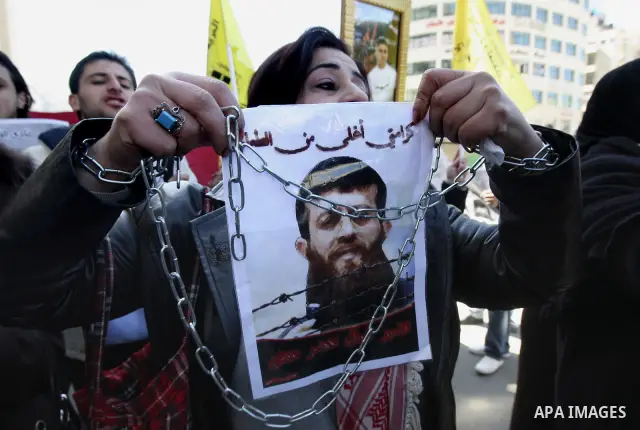Palestinians hold posters with the images of Khader Adnan Islamic Jihad leader , who is on hunger strike to protest against his detention by Israel, during a rally supporting , in the city of Nablus West Bank , Feb 21, 2...