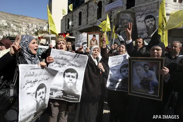 A Palestinian protestor holds a picture of Khader Adnan, 33, a senior member of Islamic Jihad jailed in Israel, during a demonstration in solidarity with Adnan, in the West Bank city of Nablus, on February 21, 2012, shor...