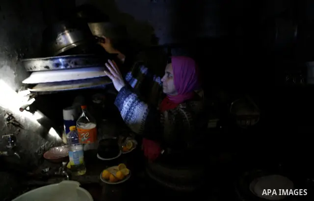 A Palestinian woman prepares food inside her bad-built home in Khan Younis refugee camp in southern Gaza Strip, 21 February 2012. The United Nations Relief and Works Agency (UNRWA) stated that the Israeli blockade on Gaz...