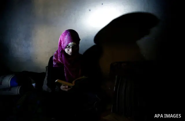 A Palestinian woman reads Holy Quran inside her bad-built home in Khan Younis refugee camp in southern Gaza Strip, 21 February 2012. The United Nations Relief and Works Agency (UNRWA) stated that the Israeli blockade on...