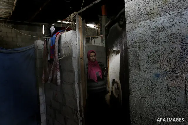 A Palestinian woman stands inside her bad-built home in Khan Younis refugee camp in southern Gaza Strip, 21 February 2012. The United Nations Relief and Works Agency (UNRWA) stated that the Israeli blockade on Gaza has m...