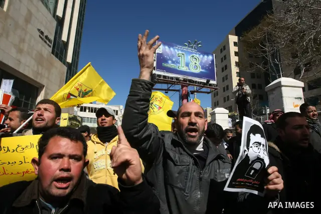 Palestinians holds a picture of Khader Adnan, a senior member of Islamic Jihad jailed in Israel, who has been on hunger strike for 66 days, during a protest calling for the release of Adnan and other Palestinians, in the...