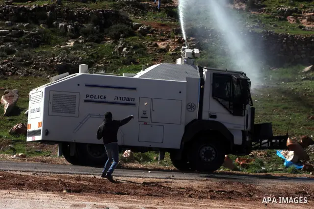 A Palestinian protester throws a stone towards Israeli troops during clashes outside Ofer prison near the West Bank city of Ramallah February 21, 2012. The clashes broke out after a protest in support of Islamic Jihad me...