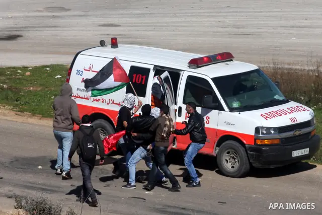 Palestinian paramedics transfer a wounded on wheel to the hospital, during a demonstration outside the entrance of Ofer Prison near Ramallah in the occupied West Bank in support of a fellow prisoner who has ended on Febr...