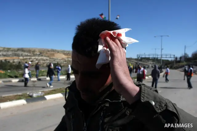 A Palestinian protester throws a stone towards Israeli troops during clashes outside Ofer prison near the West Bank city of Ramallah February 21, 2012. The clashes broke out after a protest in support of Islamic Jihad me...
