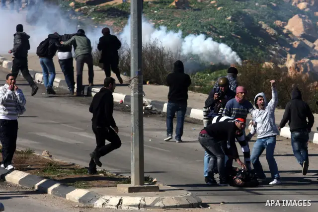 A Palestinian protester throws a stone towards Israeli troops during clashes outside Ofer prison near the West Bank city of Ramallah February 21, 2012. The clashes broke out after a protest in support of Islamic Jihad me...