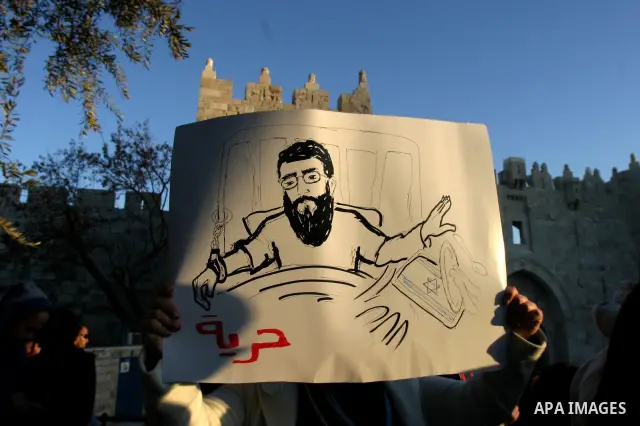 Palestinians holds a poster with a drawing depicting Islamic Jihad member Khader Adnan with a locked mouth, who has been on hunger strike for two months, during a demonstration in Jerusalem, Tuesday, Feb. 21, 2012. Adnan...