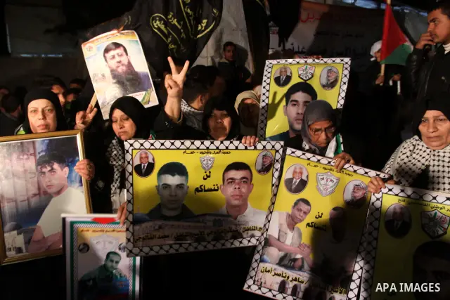 Palestinians celebrate the Israeli court decision to release Islamic Jihad member Khader Adnan from prison, in front of the Red Cross headquarters in Gaza city, Tuesday, Feb. 21, 2012. Adnan agreed to end his 66-day hung...