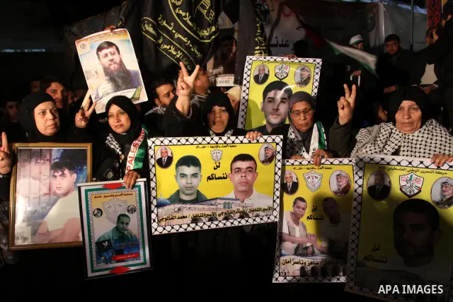 Palestinians celebrate the Israeli court decision to release Islamic Jihad member Khader Adnan from prison, in front of the Red Cross headquarters in Gaza city, Tuesday, Feb. 21, 2012. Adnan agreed to end his 66-day hung...