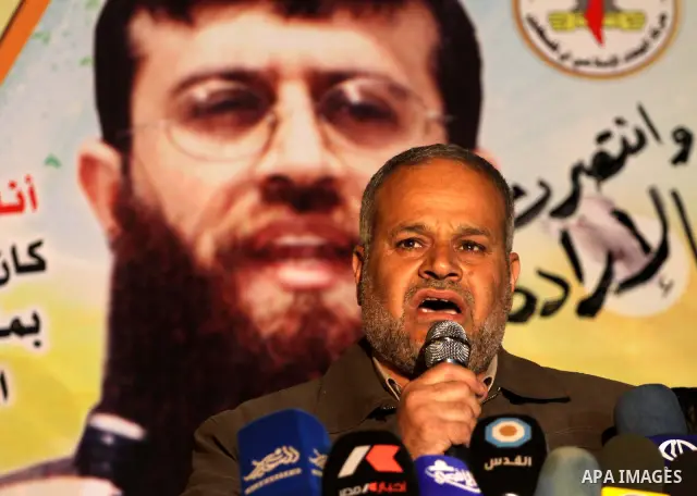 Palestinians celebrate the Israeli court decision to release Islamic Jihad member Khader Adnan from prison, in front of the Red Cross headquarters in Gaza city, Tuesday, Feb. 21, 2012. Adnan agreed to end his 66-day hung...