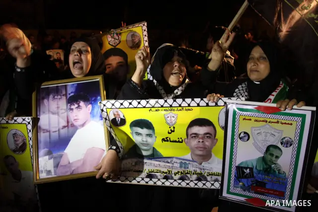 Palestinians celebrate the Israeli court decision to release Islamic Jihad member Khader Adnan from prison, in front of the Red Cross headquarters in Gaza city, Tuesday, Feb. 21, 2012. Adnan agreed to end his 66-day hung...