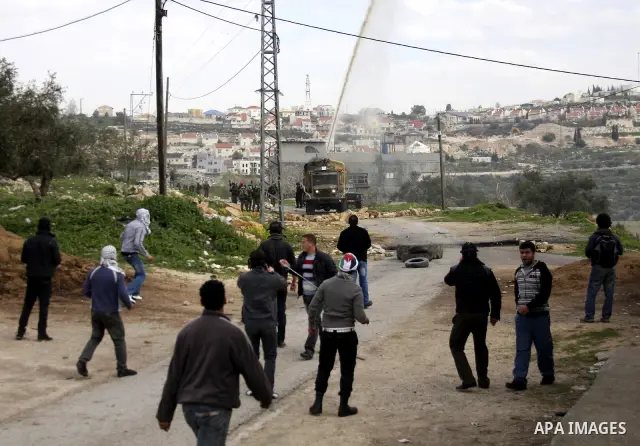 Palestinian protesters throw stones at Israeli soldiers during a demonstration against the expropriation of Palestinian land by Israel in the village of Kfar Qaddum, near the West Bank city of Nablus, on February 24, 201...