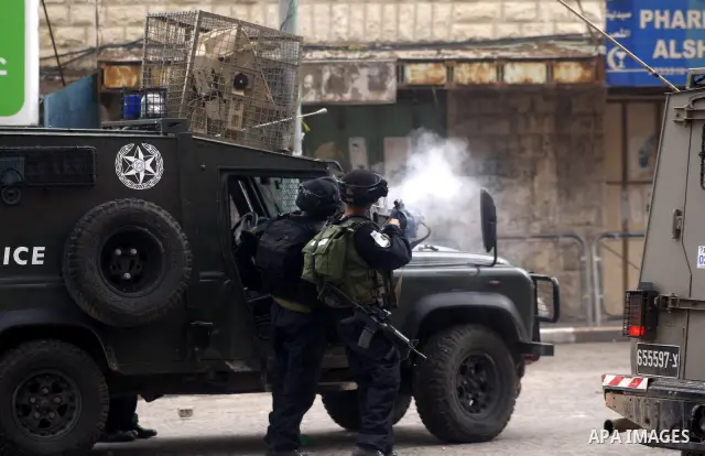 An Israeli policeman fires a tear gas canister during clashes with Palestinian protesters at a demonstration against the closure of Shuhada street to Palestinians, in the West Bank city of Hebron February 24, 2012. Some...