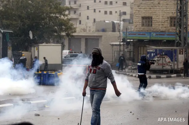 An Israeli policeman fires a tear gas canister during clashes with Palestinian protesters at a demonstration against the closure of Shuhada street to Palestinians, in the West Bank city of Hebron February 24, 2012. Some...