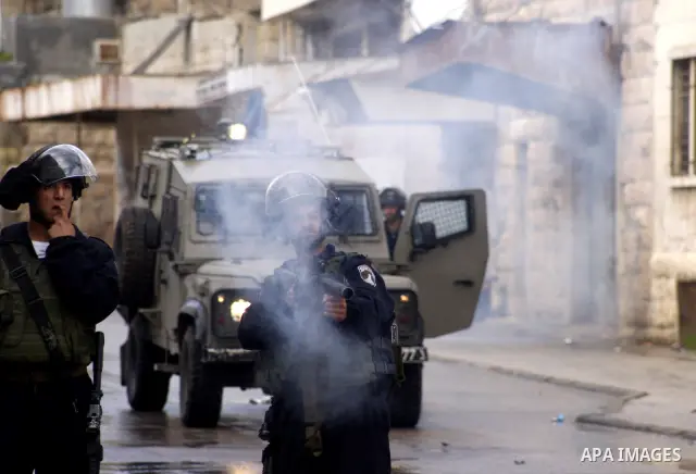 An Israeli policeman fires a tear gas canister during clashes with Palestinian protesters at a demonstration against the closure of Shuhada street to Palestinians, in the West Bank city of Hebron February 24, 2012. Some...