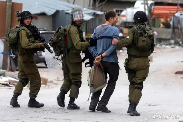 Israeli troops arrest a protester during a demonstration by Palestinians and peace activists demanding the reopening of a key street in the West Bank city of Hebron, 24 February 2012. Hundreds of Palestinians protested t...