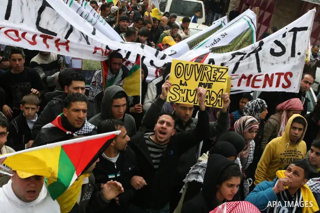 Palestinian demonstrators, joined by Israeli and foreign peace activists, shout slogans during a demonstration demanding the reopening of a key street in the West Bank city of Hebron on February 24, 2012. Hundreds of Pal...
