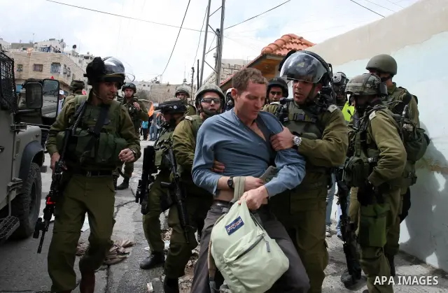 Israeli troops arrest a protester during a demonstration by Palestinians and peace activists demanding the reopening of a key street in the West Bank city of Hebron, 24 February 2012. Hundreds of Palestinians protested t...