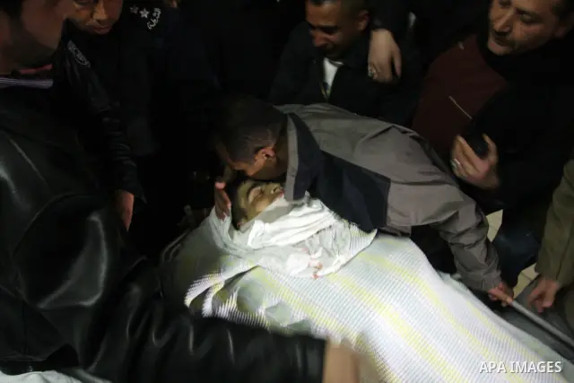 Palestinians relatives mourn over the body of Talat Ramya "25", killed by Israeli military, during clashes following a weekly demonstration at the West bank refugee camp of Qalandia, near Ramallah, on Feb. 24. 2012. Phot...