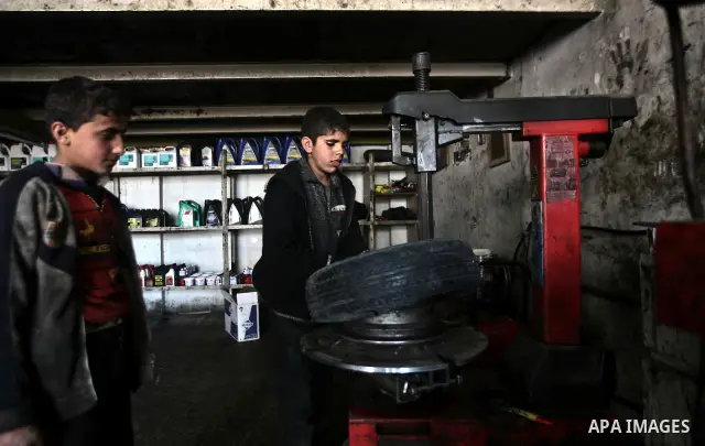 Palestinian children work repairing a car tyre in the town of Beit Lahyia in northern Gaza on 23 February 2012. Reports state that child labor is widespread in the Gaza Strip because of the high rate of poverty and unemp...
