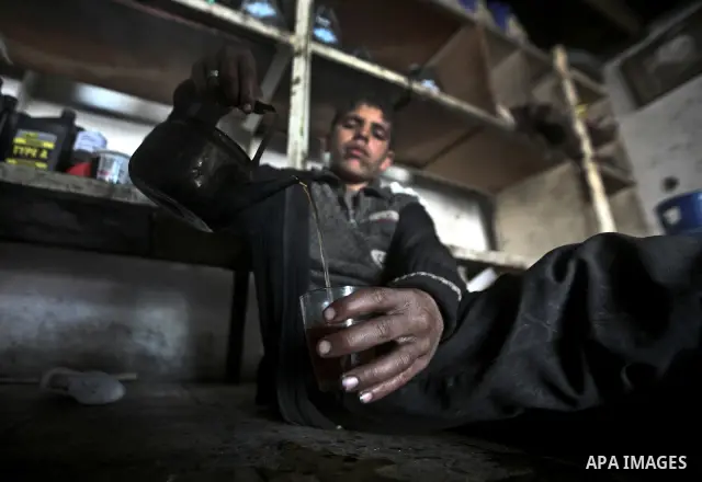 Palestinian children having their tea in a car repair workshop in the town of Beit Lahyia in northern Gaza on 23 February 2012. Reports state that child labor is widespread in the Gaza Strip because of the high rate of p...