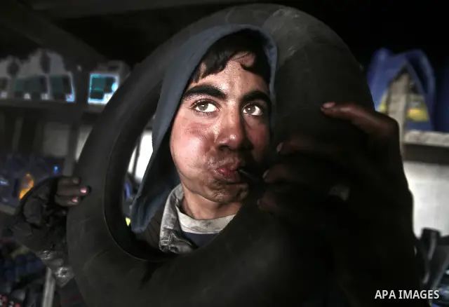 Palestinian 12 yearold Tarek, inflates an inner tube while repairing a customers car in the town of Beit Lahyia in northern Gaza on 23 February 2012. Reports state that child labor is widespread in the Gaza Strip because...