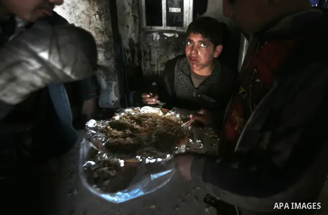 Palestinian children having their lunch in a car repair workshop in the town of Beit Lahyia in northern Gaza on 23 February 2012. Reports state that child labor is widespread in the Gaza Strip because of the high rate of...