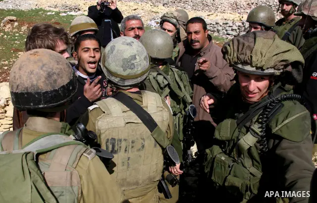 Israeli soldiers face Palestinians protesters who gathered for a protest against a Jewish settlement near the West Bank village of Beit Omar, close to the city of Hebron and the settlement of Karmei Tzur, on 25 February...