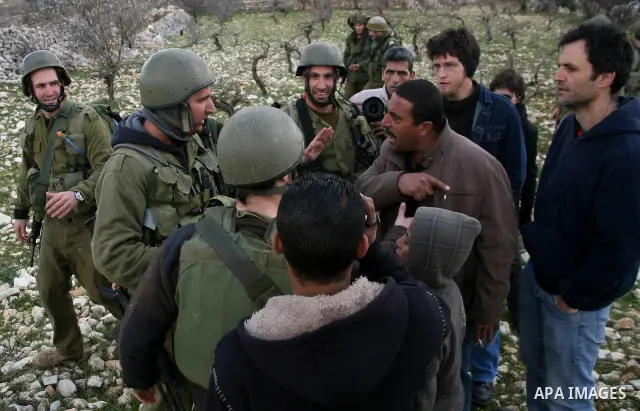 Israeli soldiers face Palestinians protesters who gathered for a protest against a Jewish settlement near the West Bank village of Beit Omar, close to the city of Hebron and the settlement of Karmei Tzur, on 25 February...