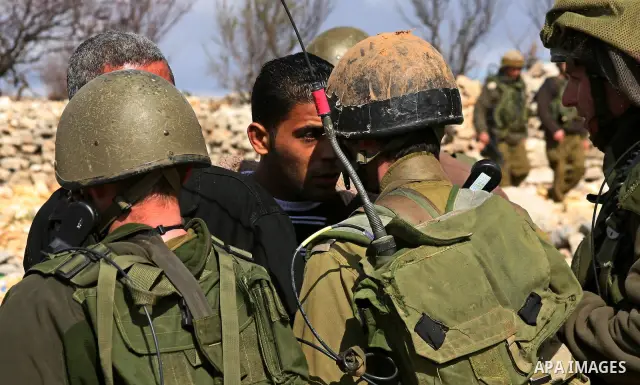 Israeli soldiers face Palestinians protesters who gathered for a protest against a Jewish settlement near the West Bank village of Beit Omar, close to the city of Hebron and the settlement of Karmei Tzur, on 25 February...