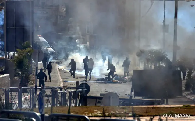 Palestinians stone thrower pelts a stone during clashes with Israeli soldiers in the West Bank neighbourhood of Al-Ram, adjacent to Israeli-annexed east Jerusalem, on February 25, 2012. At least nine Palestinians were in...