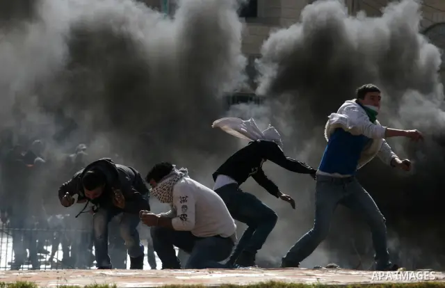 Palestinians stone thrower pelts a stone during clashes with Israeli soldiers in the West Bank neighbourhood of Al-Ram, adjacent to Israeli-annexed east Jerusalem, on February 25, 2012. At least nine Palestinians were in...