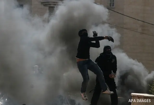 Palestinians stone thrower pelts a stone during clashes with Israeli soldiers in the West Bank neighbourhood of Al-Ram, adjacent to Israeli-annexed east Jerusalem, on February 25, 2012. At least nine Palestinians were in...