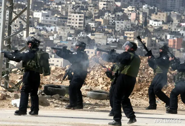Israeli soldiers take position during clashes with Palestinian stone throwers in the West Bank neighbourhood of Al-Ram, adjacent to Israeli-annexed east Jerusalem, on February 25, 2012. At least nine Palestinians were in...