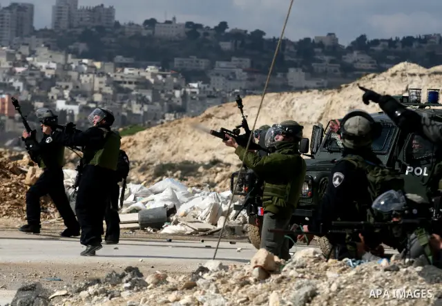 Israeli soldiers take position during clashes with Palestinian stone throwers in the West Bank neighbourhood of Al-Ram, adjacent to Israeli-annexed east Jerusalem, on February 25, 2012. At least nine Palestinians were in...